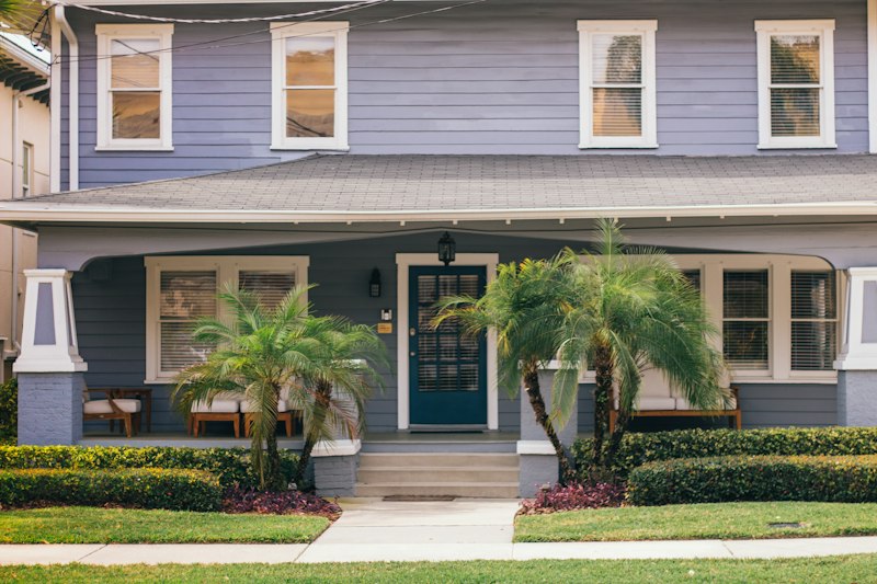 A blue house with palm trees in front